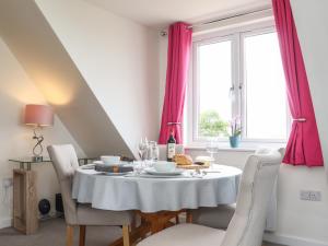 uma sala de jantar com uma mesa branca e cadeiras em Higher Kernick View em Bodmin