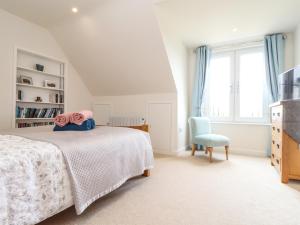 a bedroom with a bed and a chair and a window at Higher Kernick View in Bodmin