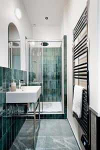 y baño con lavabo y ducha. en Edgar Suites Saint-Lazare - Amsterdam en París