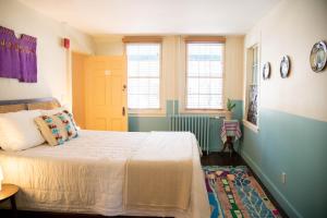 a bedroom with a bed and a yellow door and windows at The Vesper Woodstock in Woodstock