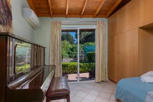 a bedroom with a bed and a sliding glass door at Villa René in Koskinou