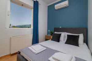a bedroom with a large bed with a large window at Ruvelis private pool villa in Fiolítis +28 photos