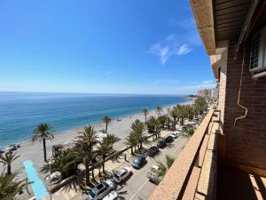 une vue sur la plage depuis le balcon d'un immeuble dans l'établissement PUSHE Playa Velilla Beach&Tradition, à Almuñécar