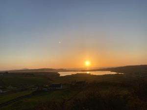a sunset over a river with the sun in the sky at Three bedroom holiday home in Port