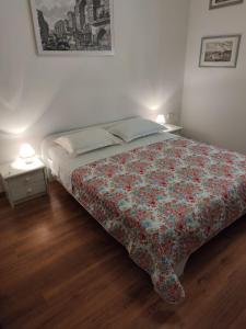 1 dormitorio con 1 cama con colcha de flores y 2 lámparas en Private Accommodation Raspudic, en Split