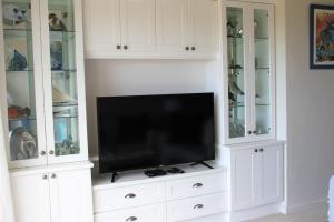 a white entertainment center with a flat screen tv at W8 - Goose Valley Golf Estate in Plettenberg Bay