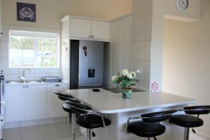 a kitchen with a island with stools and a counter top at W8 - Goose Valley Golf Estate in Plettenberg Bay