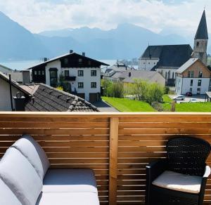 einen Balkon mit 2 Stühlen und Stadtblick in der Unterkunft Traum Panorama Apartment mit Berg & Seeblick in Altmünster