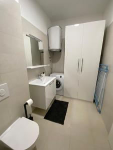 Baño blanco con aseo y lavamanos en Apartman Emanuel en Vodice