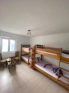 a room with three bunk beds and a table at Apartmani Milka S in Bar