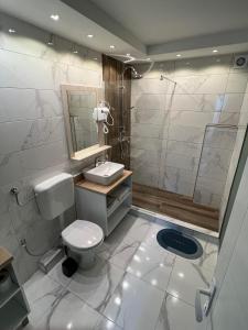 a bathroom with a toilet and a sink and a shower at Guest House Time Out in Sarajevo