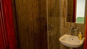 a bathroom with a shower with a sink and a mirror at Galeria PRL in Borne Sulinowo