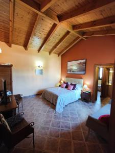 a bedroom with a bed in a room with wooden ceilings at Hotel Doñana Blues in Matalascañas