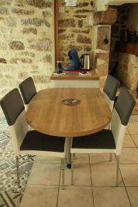 a wooden table with four chairs around it at gite de la rue droite in Turenne