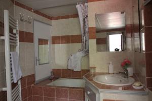 La salle de bains est pourvue d'une baignoire, d'un lavabo et d'un miroir. dans l'établissement gite de la rue droite, à Turenne