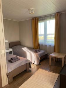 ein Zimmer mit zwei Betten und einem Fenster in der Unterkunft Dzerkaļi in Cirma