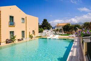 a large swimming pool next to a building at Hotel Baglio Di Scopello in Scopello