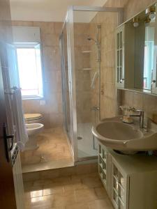 a bathroom with a sink and a shower and a toilet at Appartamento incantevole a pochi passi dal mare, Locazione breve turistica privata, no impresa in Capo dʼOrlando