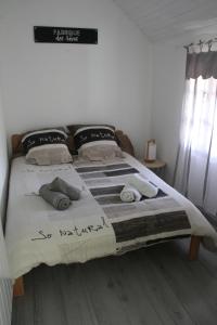 a bed in a bedroom with a sign on the wall at gite de la rue droite in Turenne