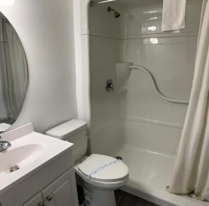 a white bathroom with a toilet and a shower at Caswell Resort in Sundridge +43 photos