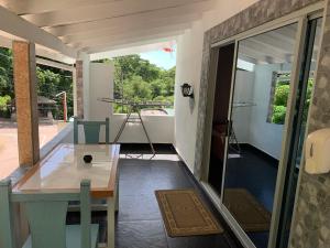 a room with a table and a balcony with a tub at Villa Manoir in Anse Lazio