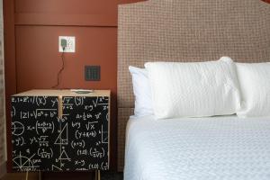 a bedroom with a bed and a chalkboard with calculations on it at The Schoolhouse Hotel in White Sulphur Springs