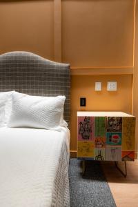 um quarto com uma cama branca e uma cabeceira azul em The Schoolhouse Hotel em White Sulphur Springs