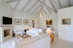 a living room with white furniture and a fireplace at Vineyard Estate in Porto Heli