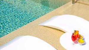 a pool with a table with a drink and snacks on it at Hotel Baglio Di Scopello in Scopello