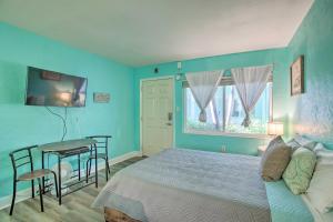 Dormitorio azul con cama y mesa en Tropical Pass-A-Grille Gem with Direct Beach Access!, en St Pete Beach