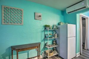 Cette chambre est dotée d'un mur bleu, d'un réfrigérateur et d'une table. dans l'établissement Tropical Pass-A-Grille Gem with Direct Beach Access!, à St. Pete Beach