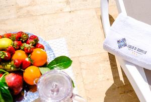 a bowl of fruit on a table next to a chair at Hotel Baglio Di Scopello in Scopello