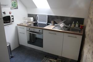 una pequeña cocina con fregadero y microondas en gite de la rue droite en Turenne