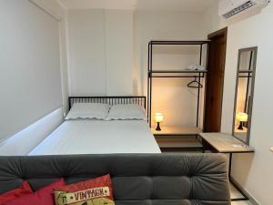 a bedroom with a large bed and a couch at Studio Maria Ziláh 2 Master Collection in Passo Fundo