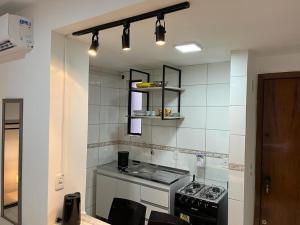 a kitchen with a stove and a counter top at Studio Maria Ziláh 2 Master Collection in Passo Fundo