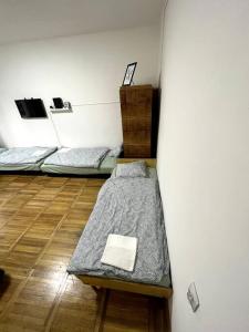 a room with three beds and a surfboard at Hangulatos lakás Budapest zöld övezetében in Budapest