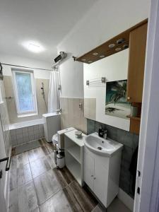 a white bathroom with a sink and a toilet at Hangulatos lakás Budapest zöld övezetében in Budapest