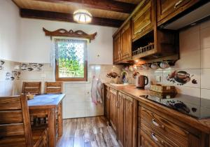 a kitchen with wooden cabinets and a table in it at Jakubowy Domek in Cisna