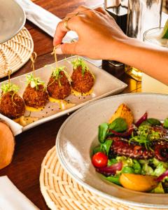 una mesa con un plato de comida y un tazón de ensalada en Vila Kalango en Jericoacoara