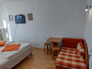 um quarto com uma cama, uma mesa e uma televisão em HannaH - Relax dom pod orechom - 2i rodinné štúdio so zdieľanou kuchyňou em Trávnica