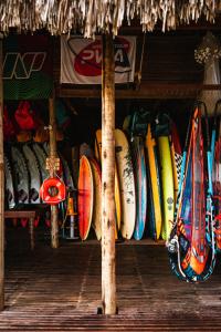 un montón de tablas de surf están alineadas en un estante en Vila Kalango, en Jericoacoara