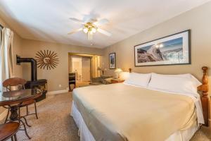 a bedroom with a large white bed and a table at Big Creek Inn in Fish Camp