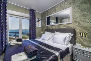 een slaapkamer met een bed en uitzicht op de oceaan bij Villa Belissima Vista Mare in Selce