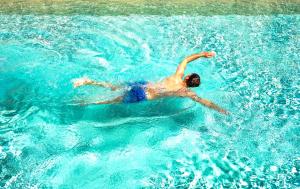 a man swimming in a pool in the water at Hotel Baglio Di Scopello in Scopello