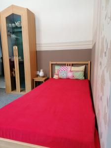 a bedroom with a bed with a red blanket at Brummers Ferienwohnung in Wildemann