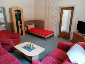 ein Wohnzimmer mit einem roten Sofa und einem Tisch in der Unterkunft Brummers Ferienwohnung in Wildemann