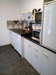 a kitchen with white cabinets and a black counter top at Ju-Ma-Pfeiffers-FeWo in Dobel