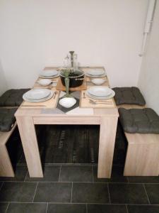 a wooden table with plates and a pot on it at Ju-Ma-Pfeiffers-FeWo in Dobel