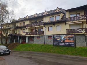 un edificio con balcones y un coche aparcado delante de él en Apartmán Sedmička Horec, en Donovaly