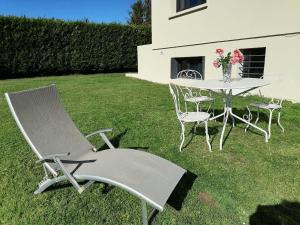 a table and chairs in a yard with a table and chairs at GITE L'Orée Deauvillaise 5 minutes DeauvilleTrouville in Bonneville-sur-Touques